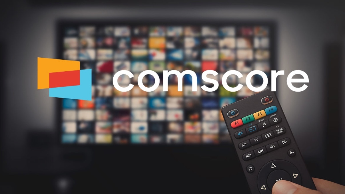 A TV remote control over a blurred screen on background